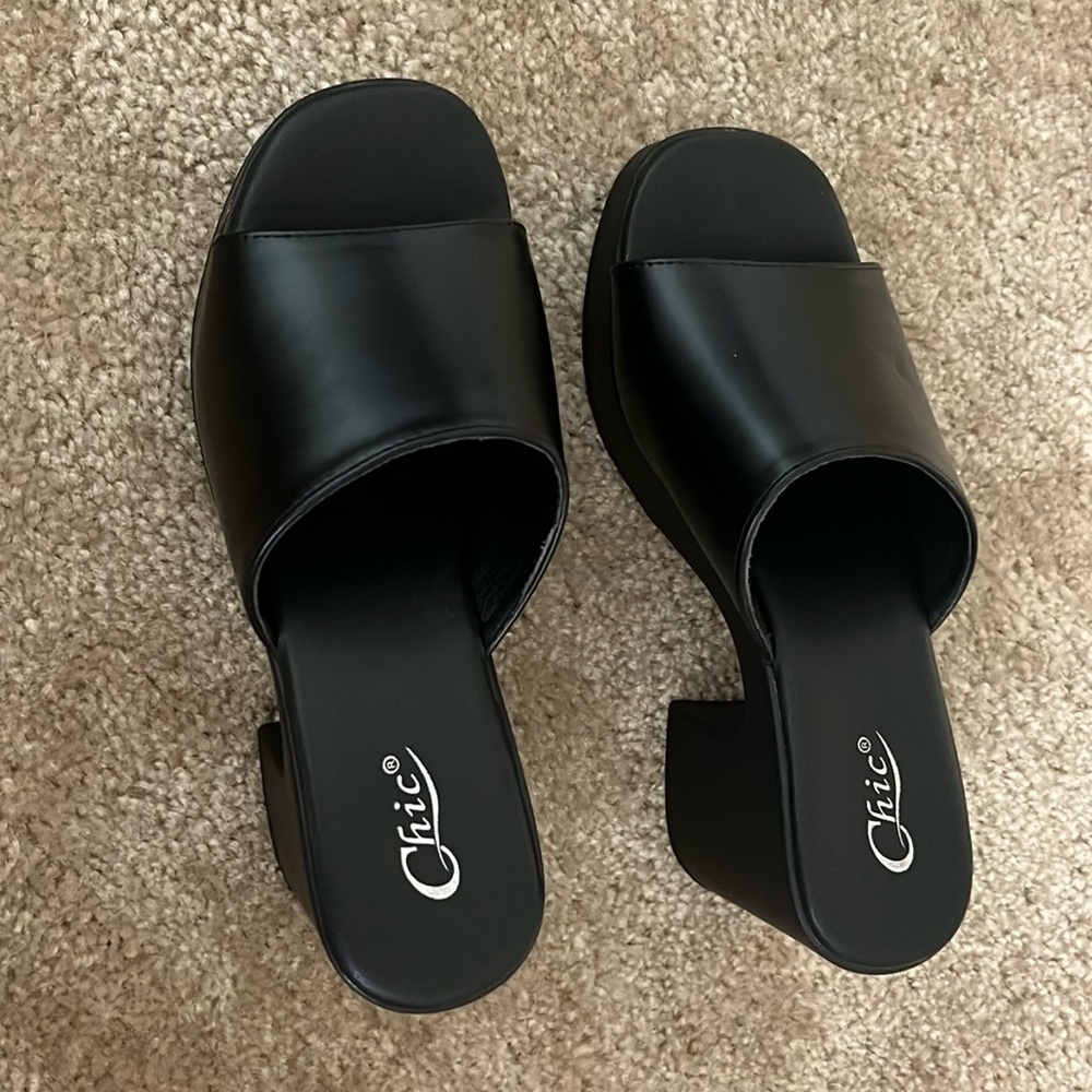 Black platformed heels, open in the front. Very chic and elegant. Never worn.